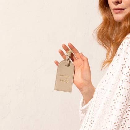 Katie Loxton Luggage Tag 'Adventure Awaits' In Taupe